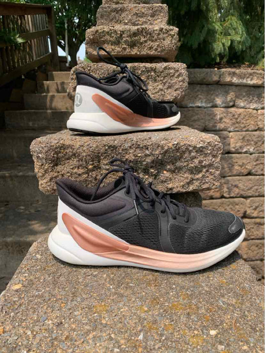 Black and white women's sneaker with rose gold swoosh and breathable mesh upper.