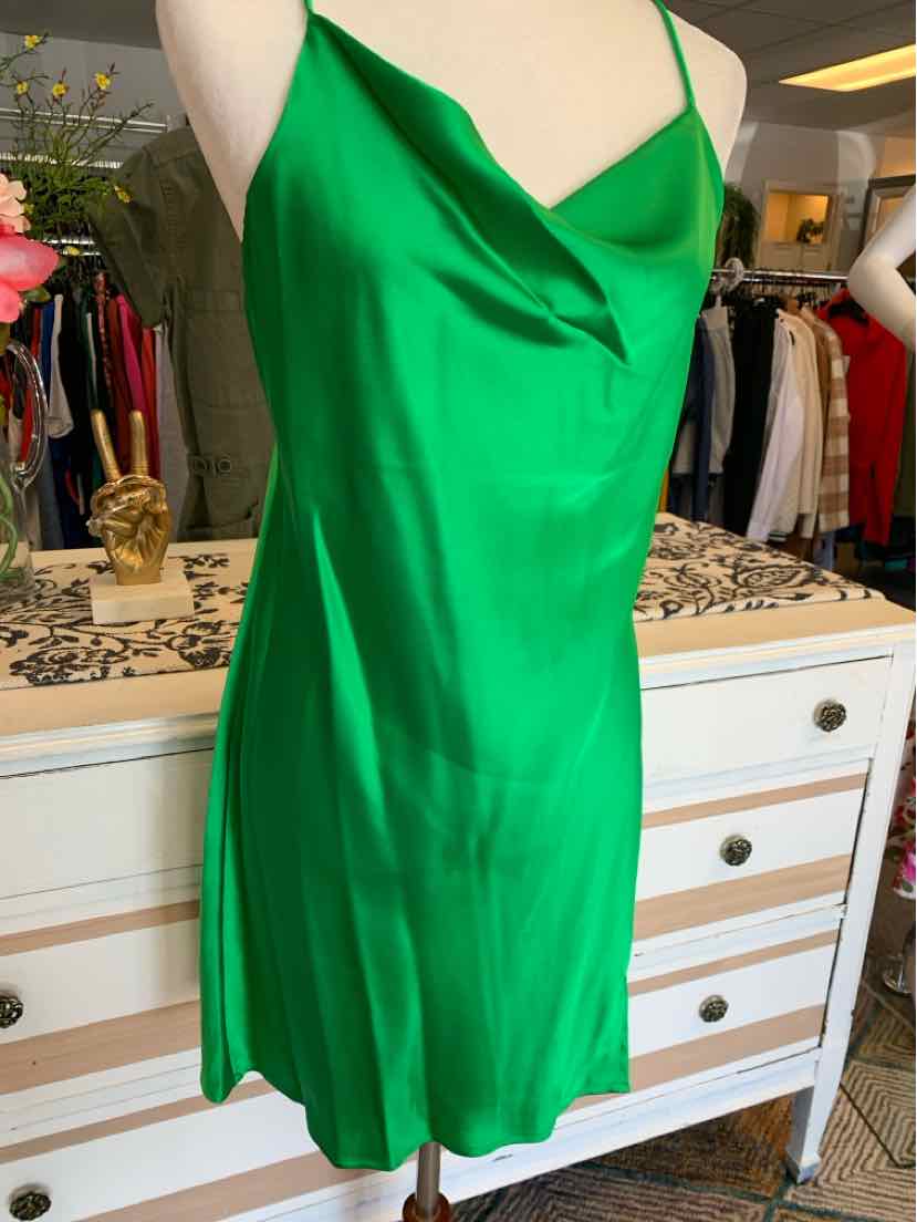 Green satin slip dress with cowl neckline and thin spaghetti straps on a mannequin.