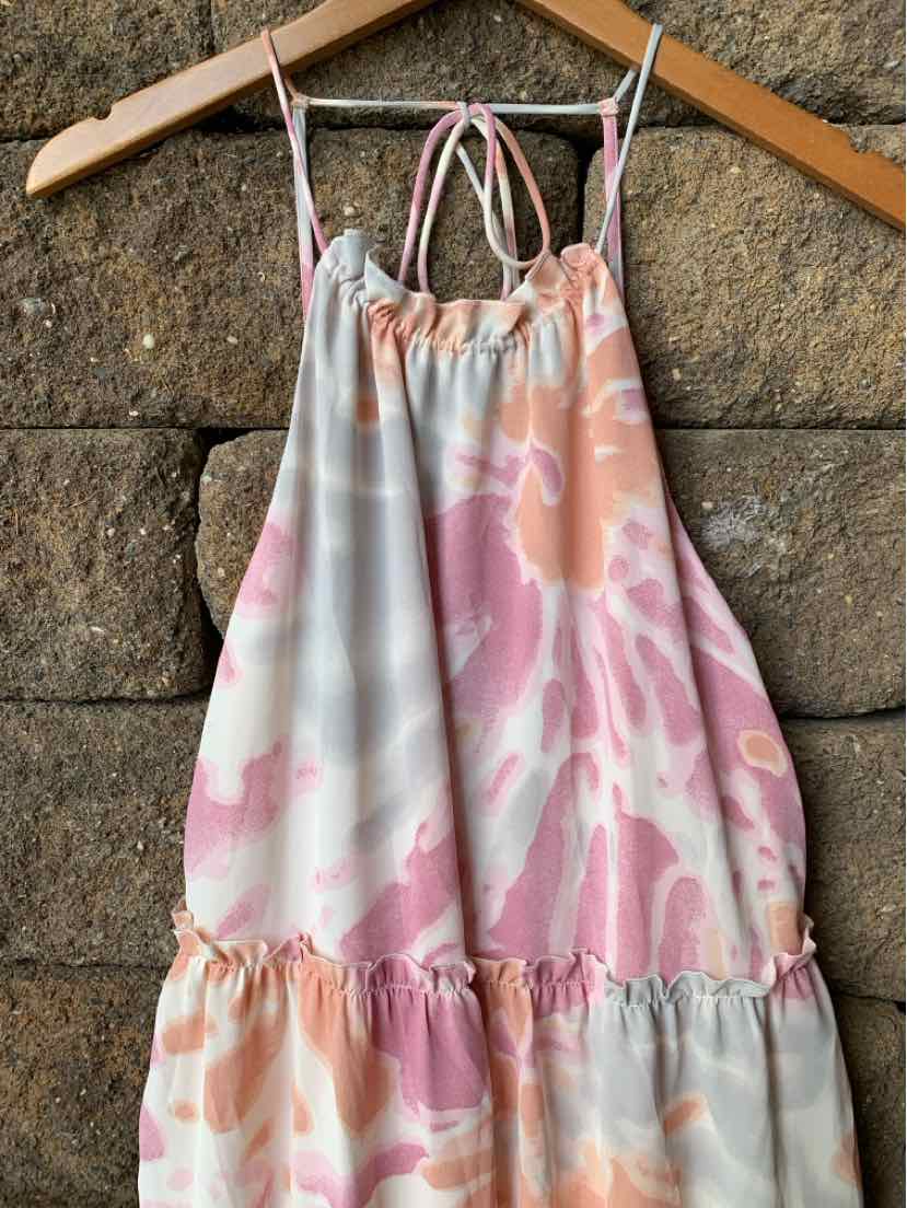 Pink and peach watercolor-patterned sleeveless dress with thin spaghetti straps and gathered ruffle hem.