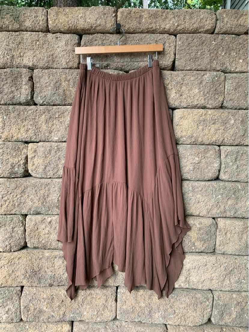 Brown flowy asymmetrical midi skirt with gathered waistband and soft pleats.