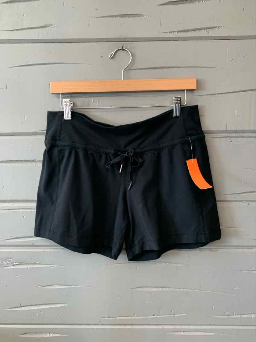 Black casual shorts with elastic waistband and drawstring, lightweight fabric, orange tag on side.