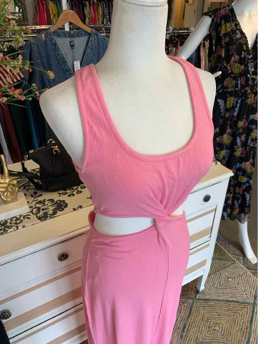 Pink sleeveless dress with scoop neckline and waist cutout tied in front, soft fabric.