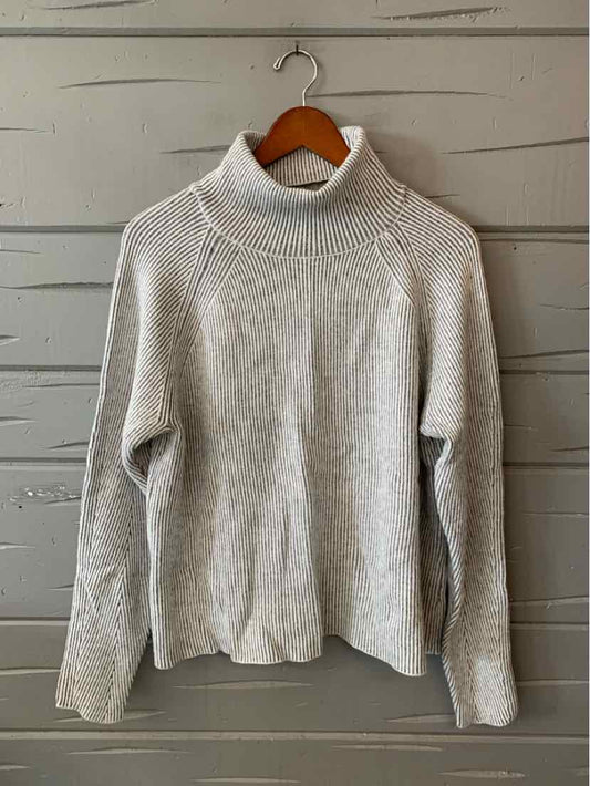 Light gray ribbed turtleneck sweater with long sleeves and a relaxed fit.