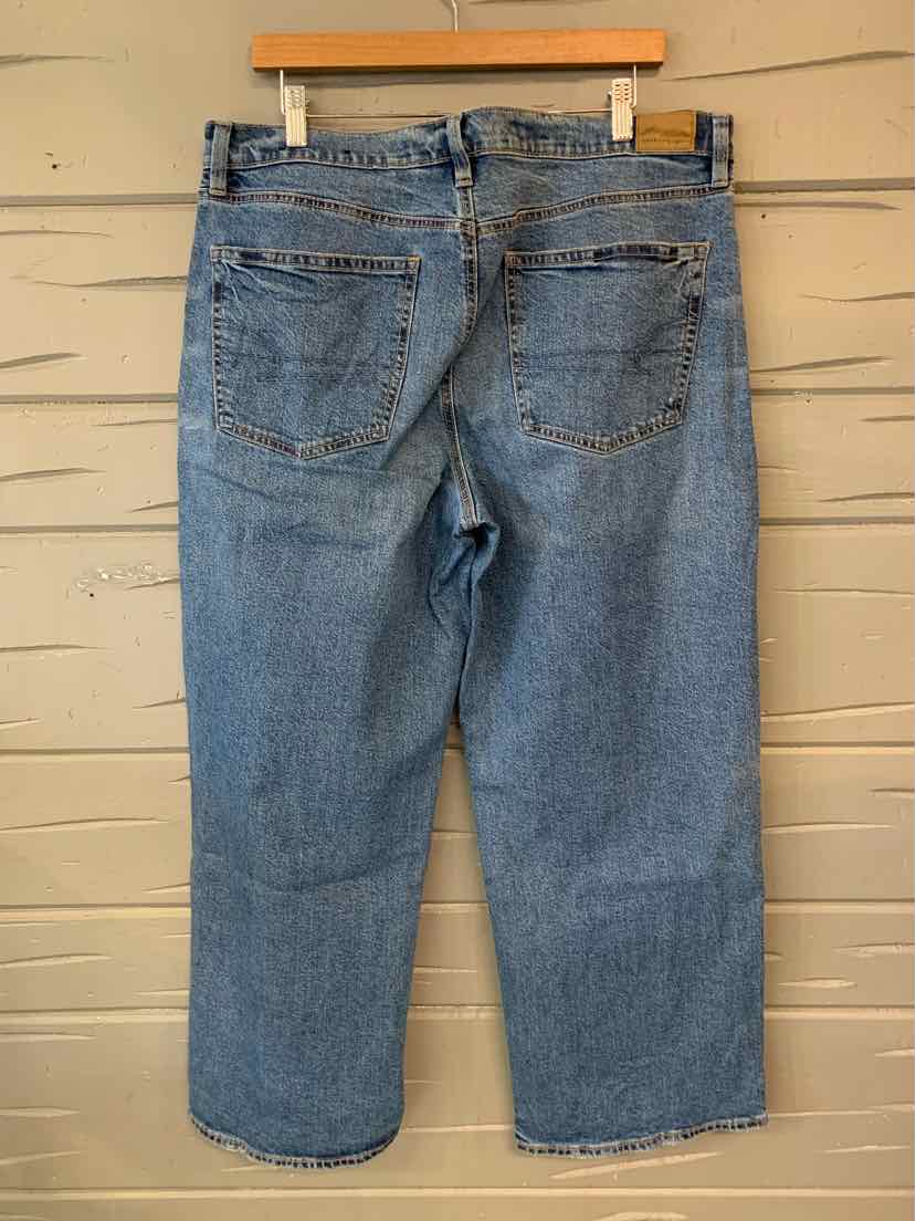 Light blue denim jeans with a relaxed fit, back view showing two patch pockets and belt loops.