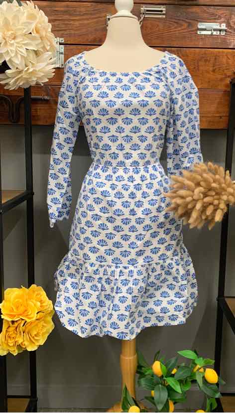 Light blue dress with white geometric pattern, long sleeves, fitted waist, and ruffled hem.