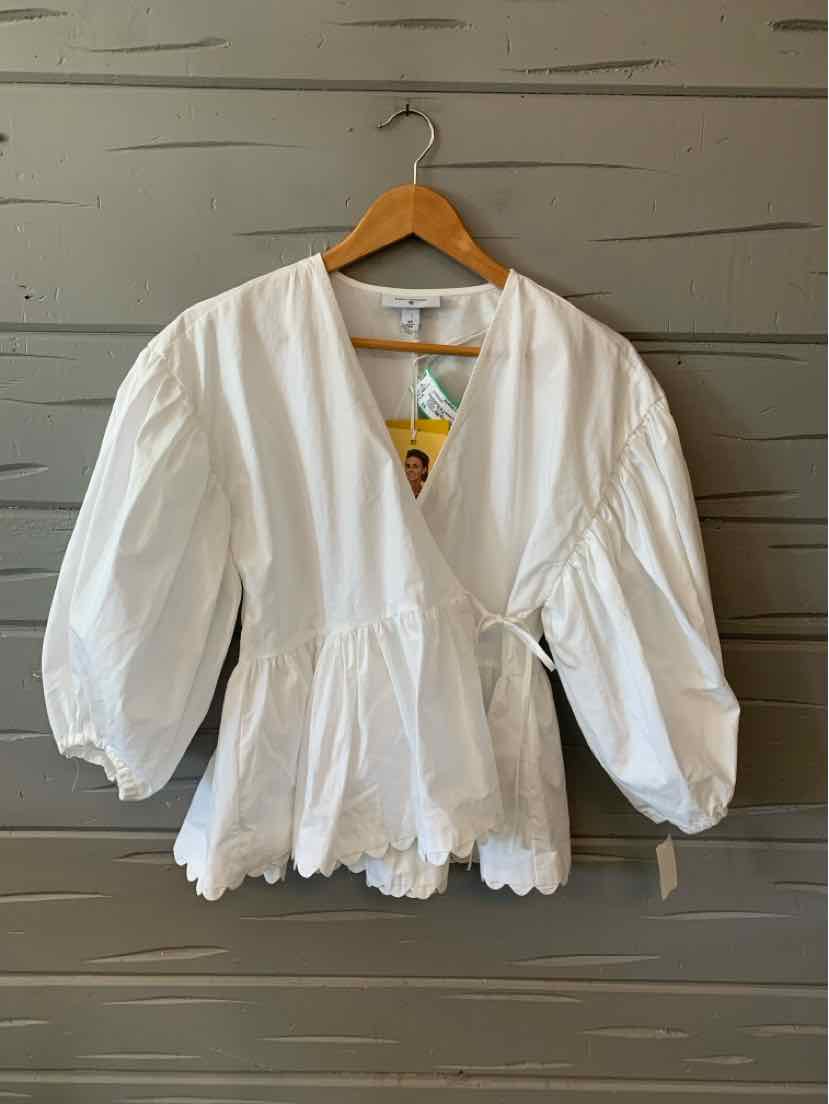 White cotton wrap blouse with V-neck, puff sleeves, scalloped hem, and side tie closure.
