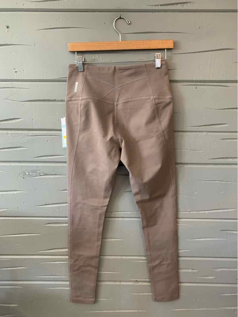 Brown high-waist athletic leggings with front seams and smooth, stretchy fabric hanging on wooden hanger.