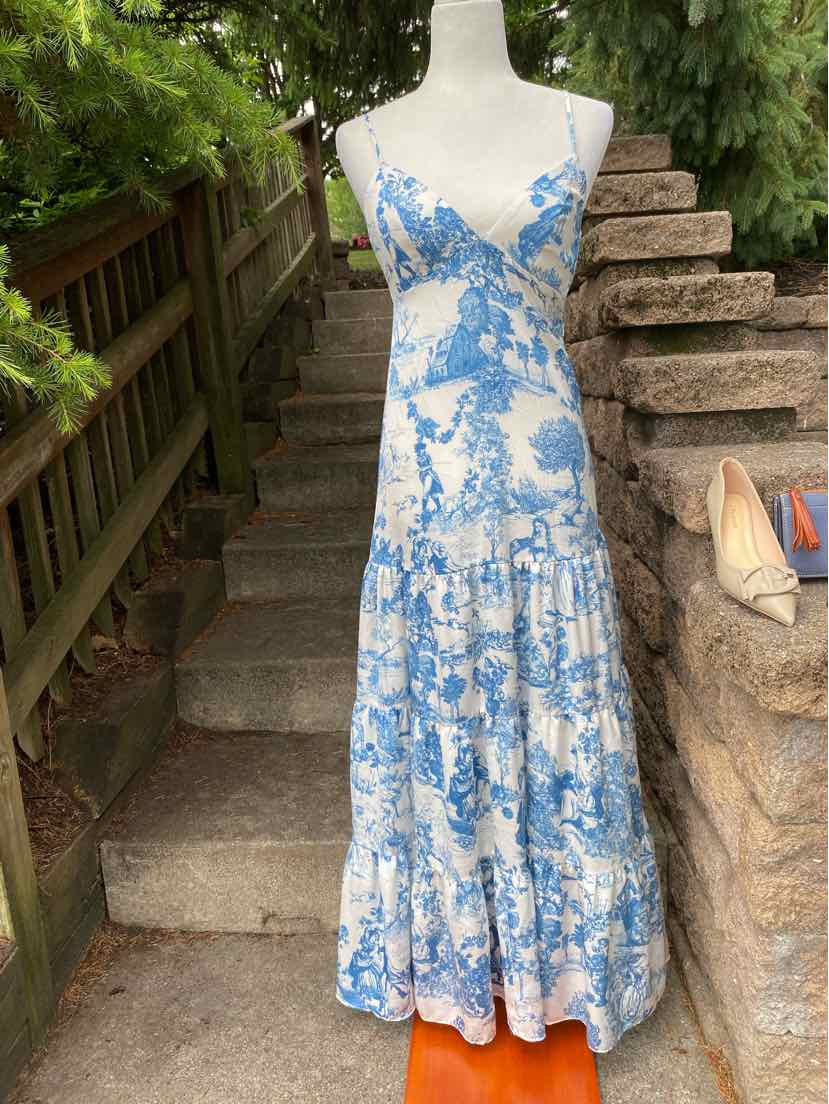 Blue and white floral maxi dress with spaghetti straps and tiered skirt on mannequin.
