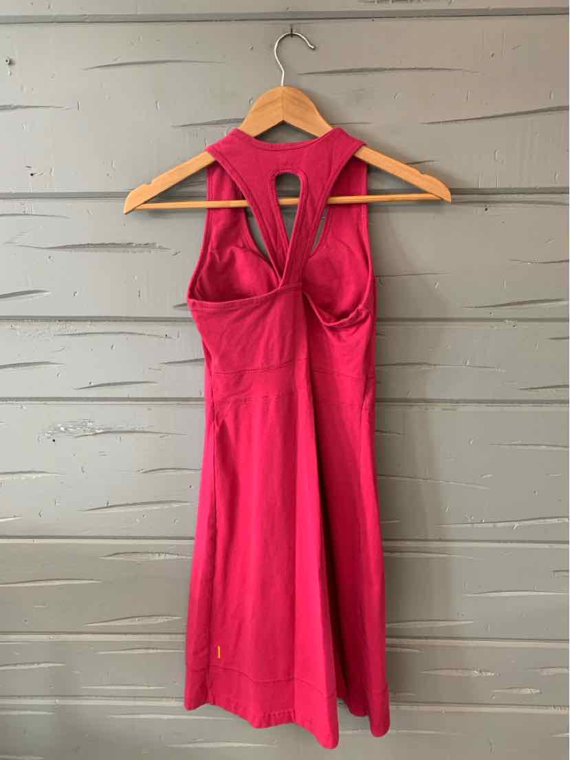 Pink sleeveless dress with racerback and cutout detail, fitted waist, knee-length hem.