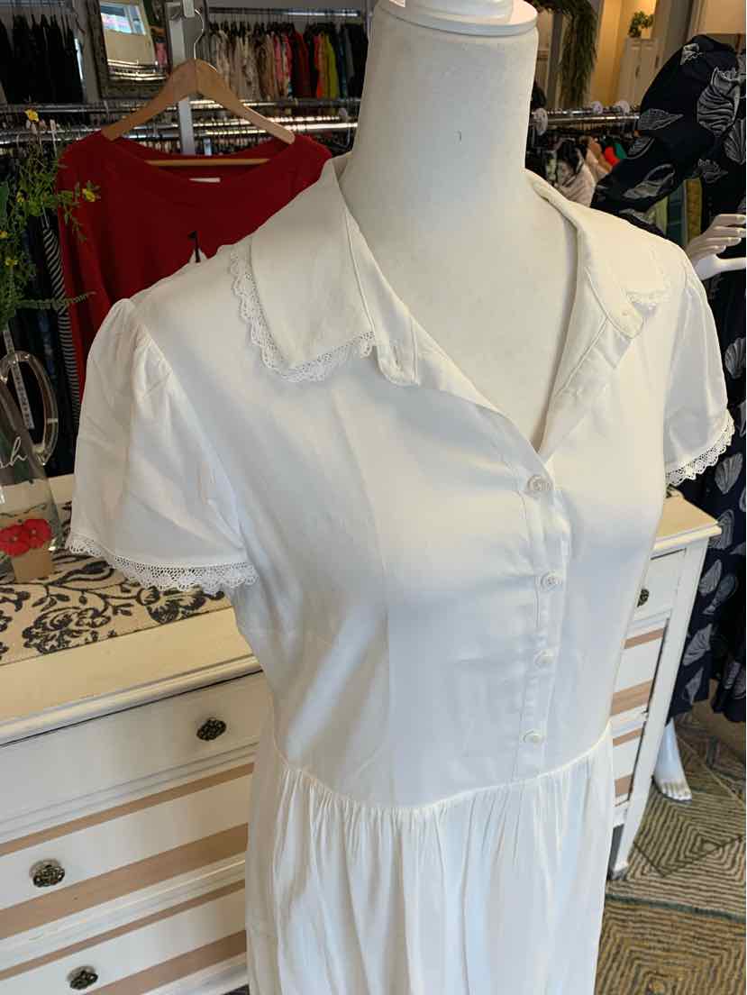 White short-sleeve button-up dress with collar and gathered waist in lightweight fabric.