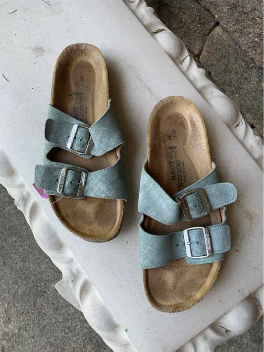 Light blue leather sandals with adjustable buckle straps and contoured cork footbeds in size 40.