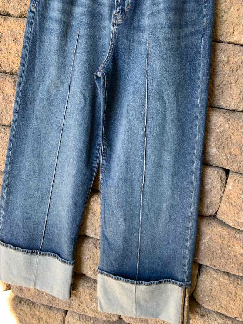 Blue denim jeans with straight legs, contrast stitching, and wide folded cuffs.