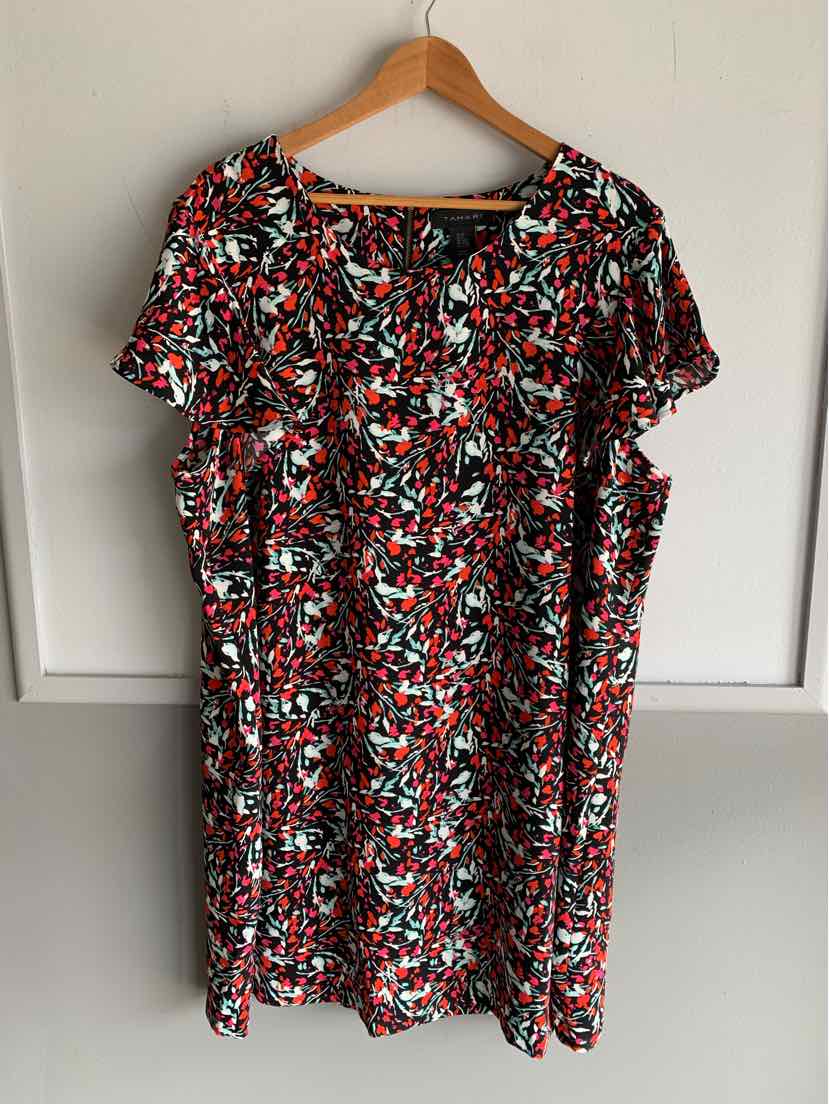 Black floral plus-size dress with short sleeves and ruffle details on wooden hanger.