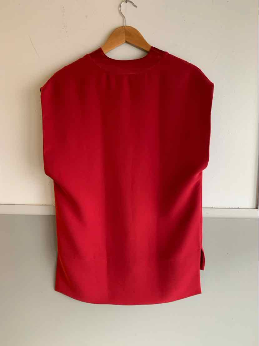Sleeveless red top with high neckline and straight hem on wooden hanger.