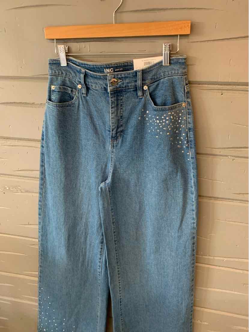 Light blue denim jeans with high waist and small silver studs on front right pocket area, size 6.