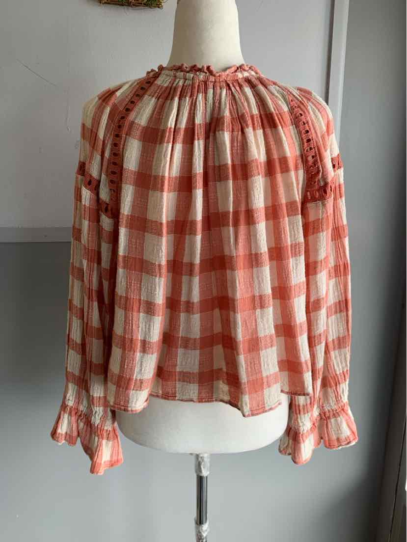 Peach and white gingham long-sleeve blouse with gathered neckline and ruffled cuffs.