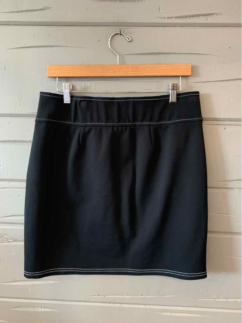 Black medium-length skirt with a straight cut and subtle seam detailing, hanging on a wooden hanger.