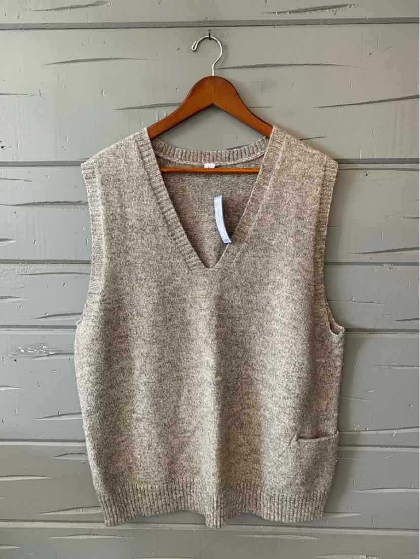 Light gray-beige knit sleeveless sweater vest with a V-neck and front patch pockets, hanging on a wooden hanger.