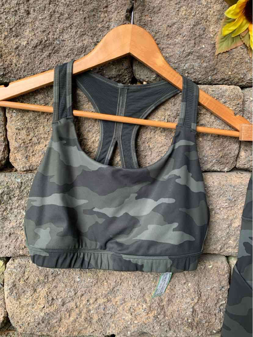 Women’s camo sports bra in muted green and black with racerback design and elastic underband.