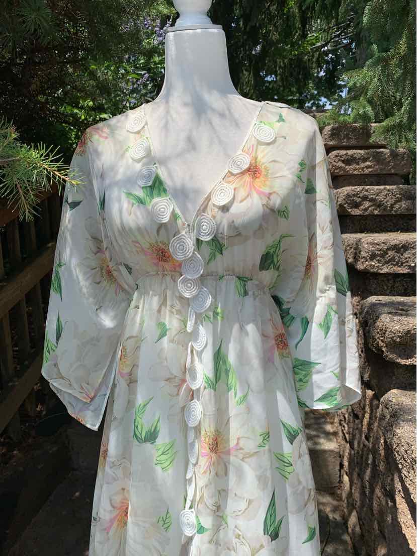 White wrap dress with pastel floral print, V-neckline, elbow-length puffy sleeves, and cinched waist.