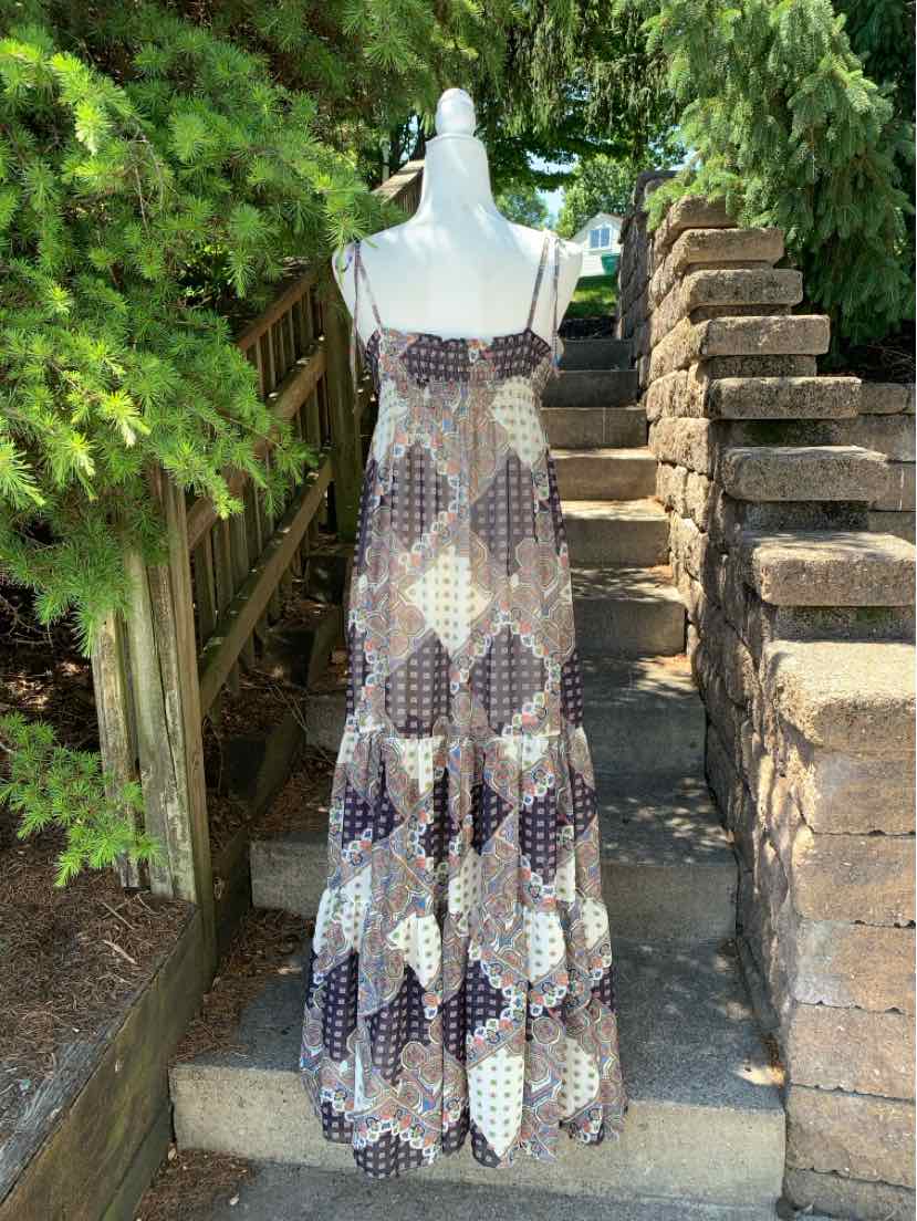 Long sleeveless maxi dress with brown and beige paisley diamond pattern and thin straps.