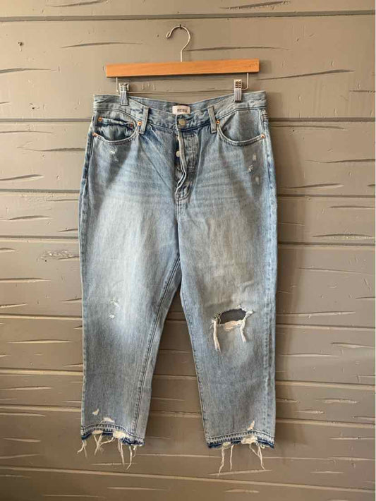 Light wash denim jeans with distressed knee and frayed hems, mid-rise fit in size 12.