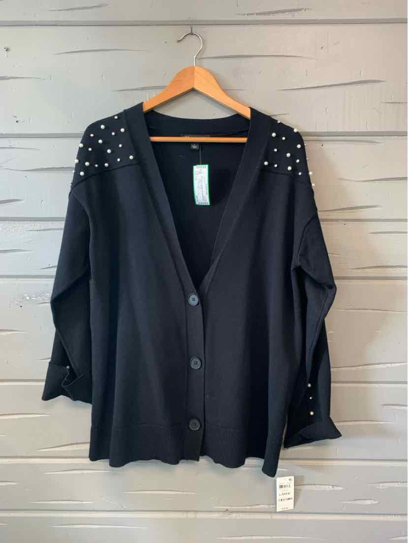 Black oversized cardigan with pearl embellishments on shoulders and sleeves, button-front closure.