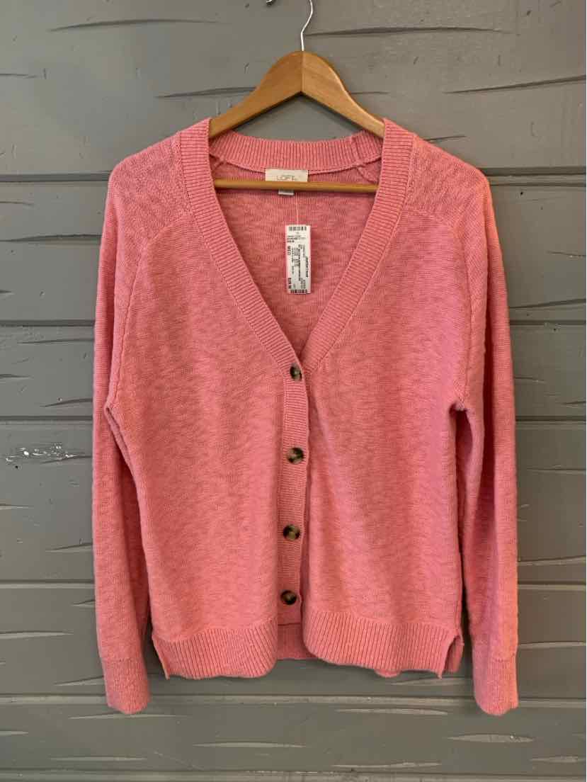 Medium pink V-neck cardigan sweater with buttons, long sleeves, and a soft knit texture on a wooden hanger.