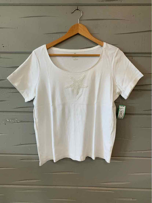 White short-sleeve scoop neck T-shirt size 1X on wooden hanger against gray wall.