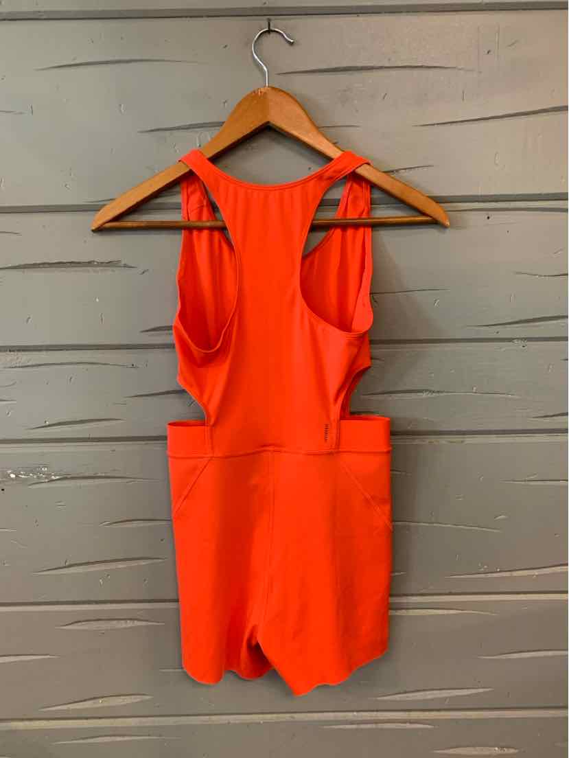 Bright orange sleeveless romper with a racerback and fitted waist in lightweight fabric.