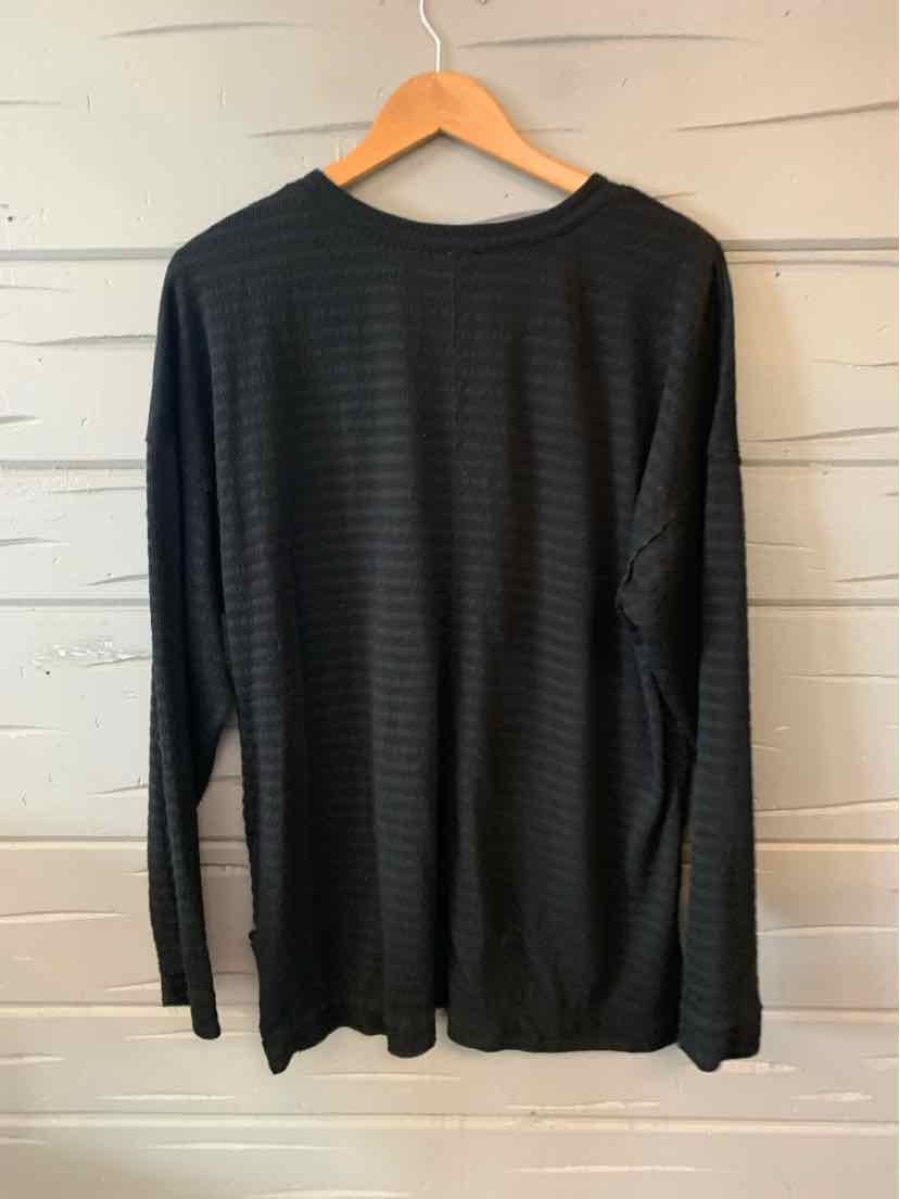 Black long-sleeve crew neck shirt with subtle horizontal stripes, loose fit, hanging on wooden hanger.