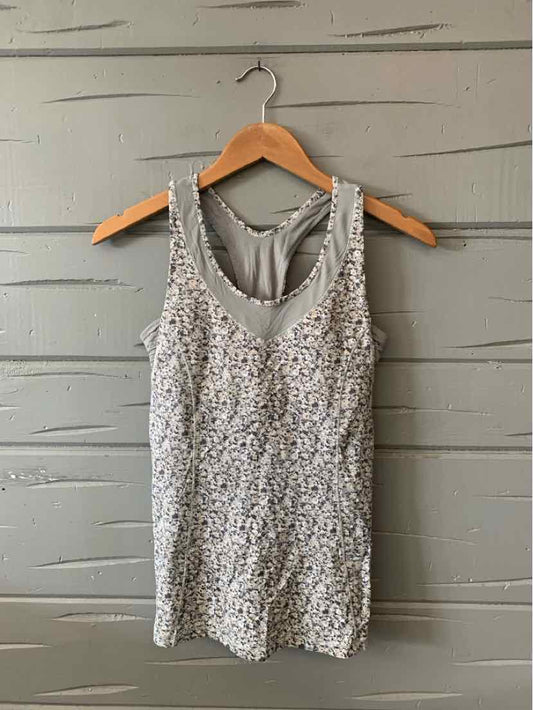 Gray sleeveless athletic tank with subtle textured pattern and scoop neckline on wooden hanger.