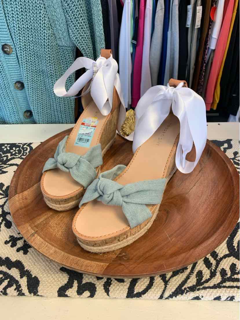 Light blue wedge sandals with white ankle tie ribbons and woven jute platform soles.