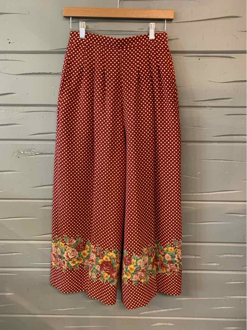 Red wide-leg pants with white polka dots and floral border print at hem, elastic waistband.