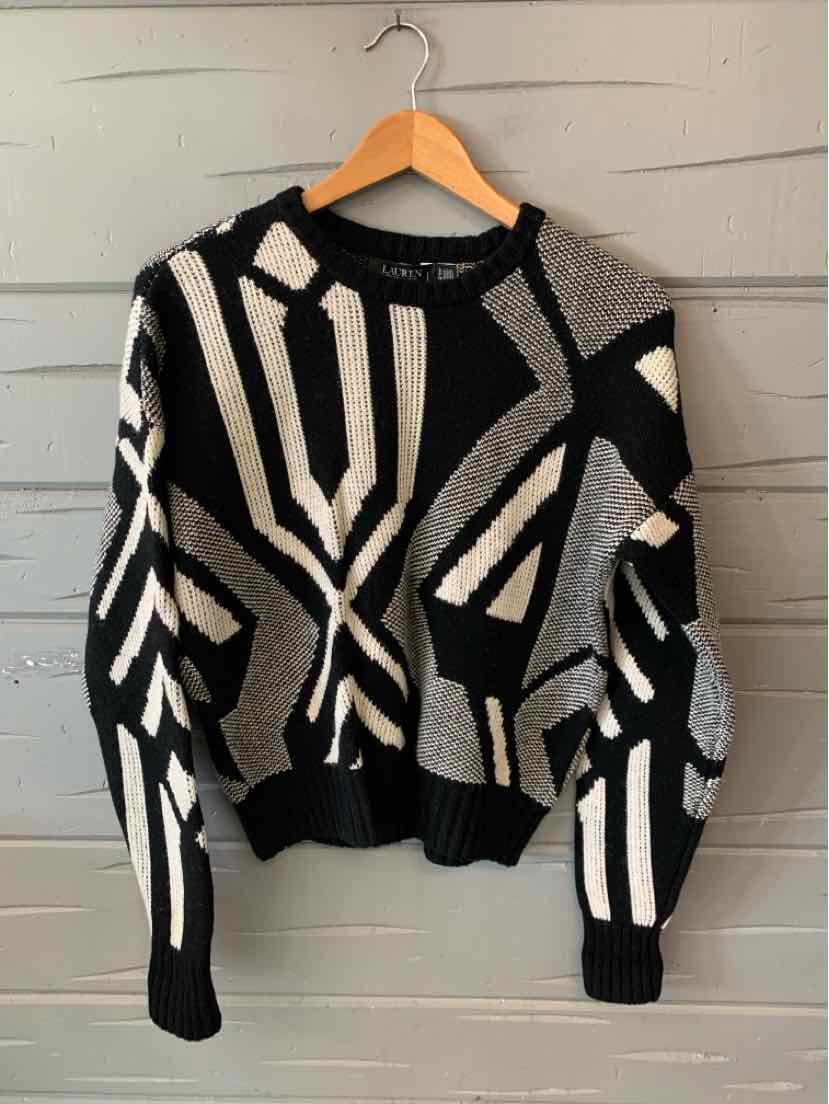 Black and white geometric print knit sweater with long sleeves and ribbed cuffs and hem.