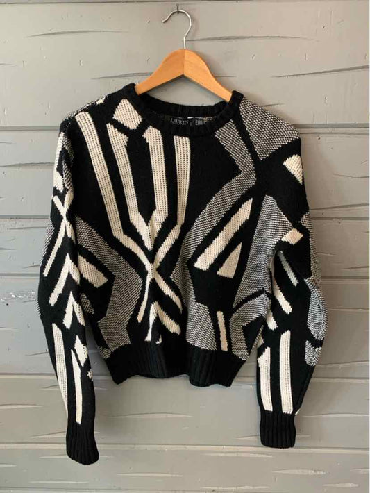 Black and white geometric print knit sweater with long sleeves and ribbed cuffs and hem.
