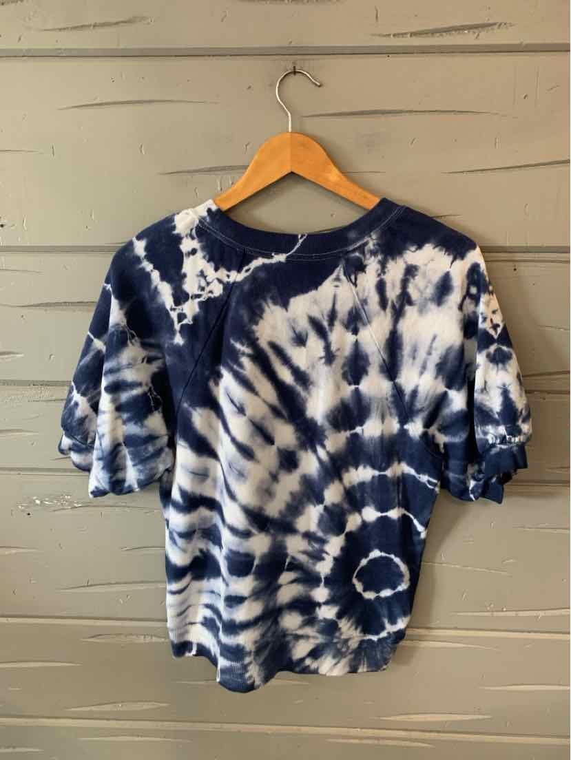 Navy and white tie-dyed short-sleeve cotton T-shirt with crew neck on wooden hanger.