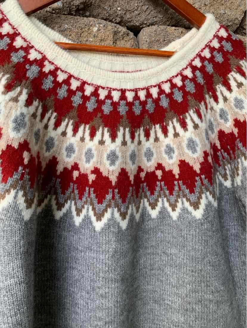 Gray knit sweater with a red, white, and navy Fair Isle pattern around the crew neck and shoulders.
