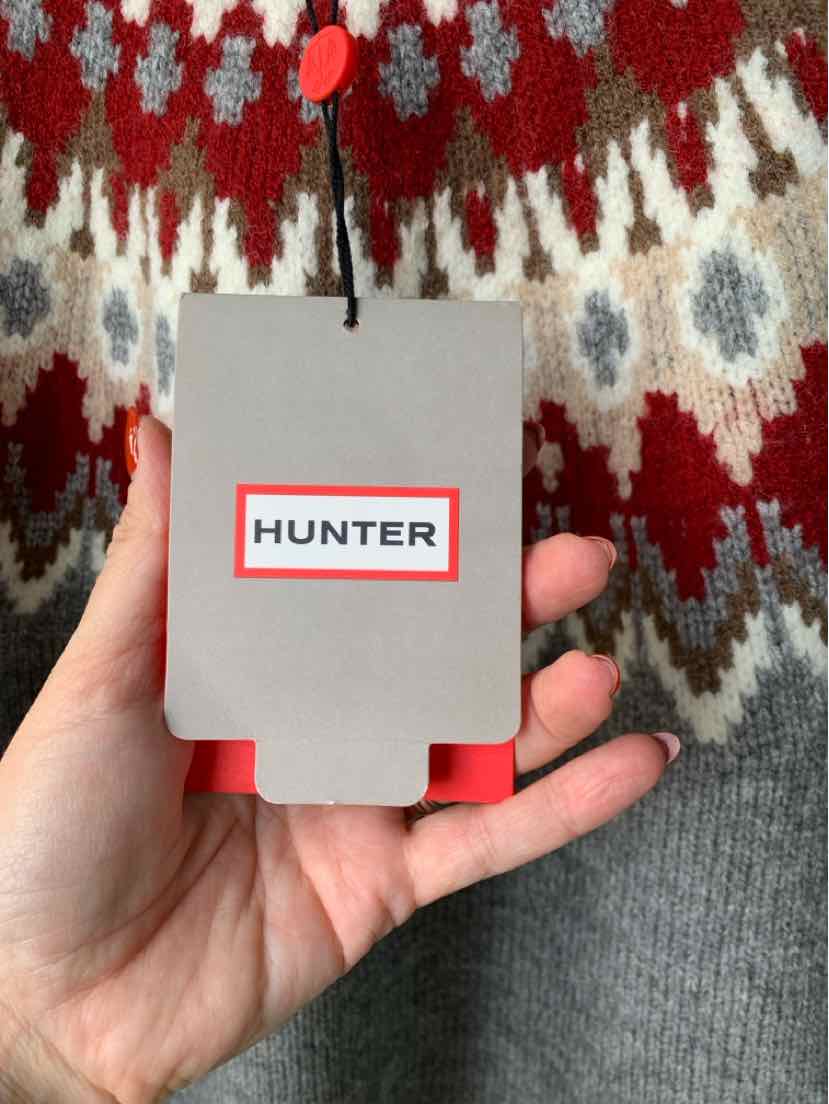 Gray HUNTER clothing tag held against a red, gray, and white Fair Isle knit sweater.