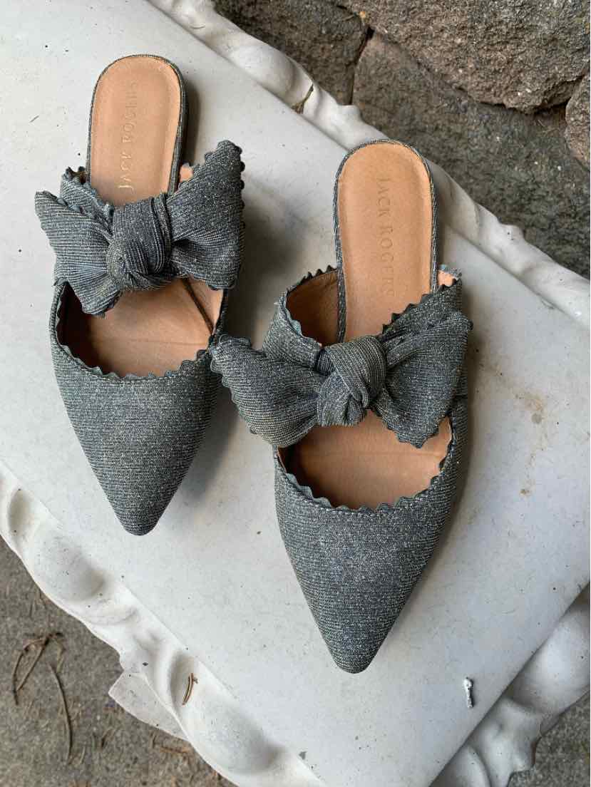Gray fabric pointed-toe slip-on flats with large decorative bows and scalloped edges.