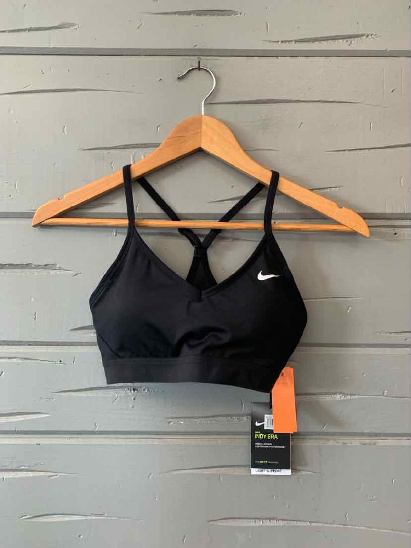 Black Nike sports bra with thin crisscross straps and small white swoosh logo on front.