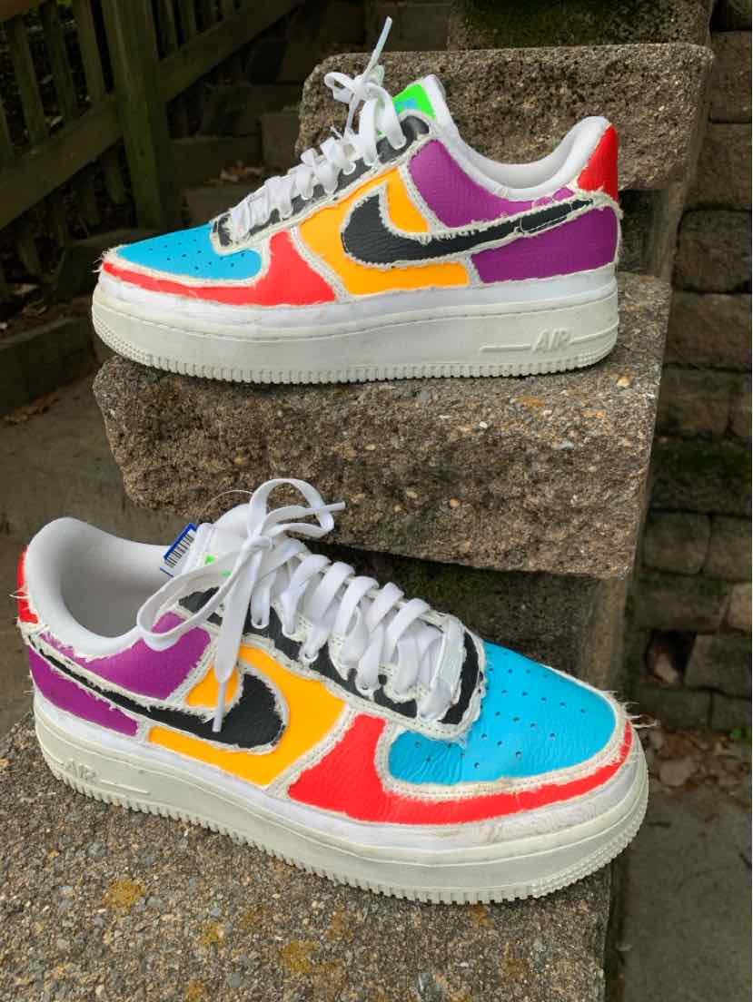 Pair of multicolor Nike sneakers with white soles, turquoise toe panels, orange and purple accents, and white laces.
