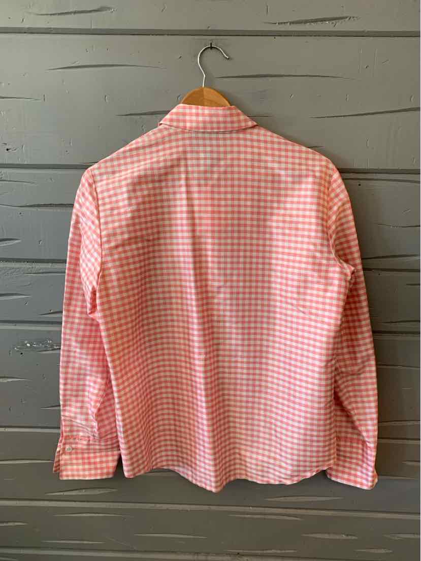 Pink and white gingham long-sleeve button-up shirt hanging on wooden hanger.