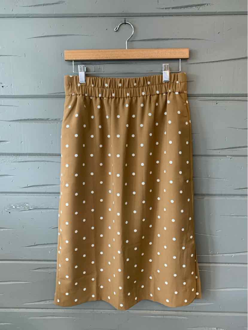Tan A-line skirt with white polka dots, elastic waistband, midi length.