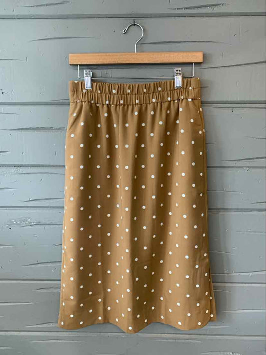 Tan A-line skirt with white polka dots, elastic waistband, midi length.
