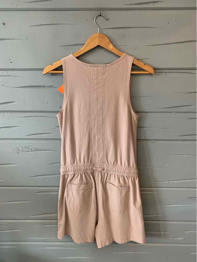 Tan sleeveless romper with elastic waistband and crew neckline, made from soft fabric.