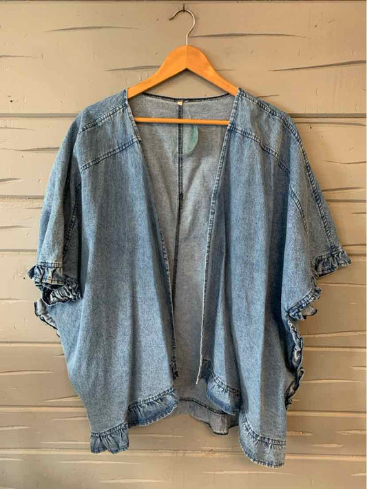 Oversized blue denim kimono jacket with open front and rolled-up cuff sleeves hanging on wooden hanger.