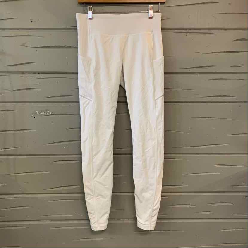 Women's white high-waist leggings with subtle seam detailing and slim fit hanging against gray wooden background.