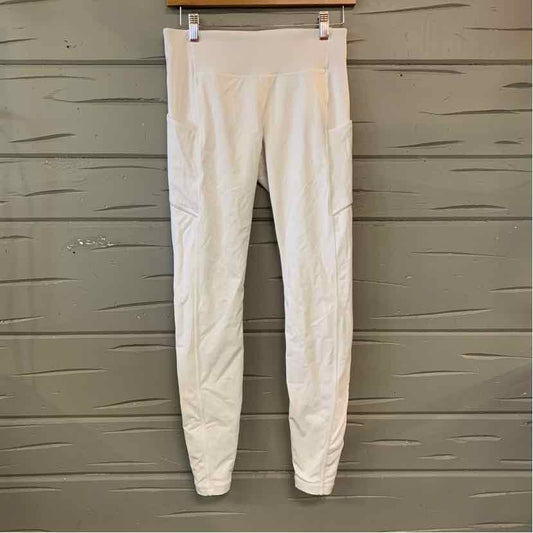 Women's white high-waist leggings with subtle seam detailing and slim fit hanging against gray wooden background.