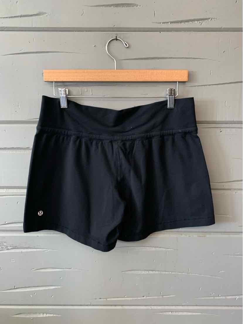 Black women's athletic shorts with a wide waistband and a small reflective logo on the left leg.